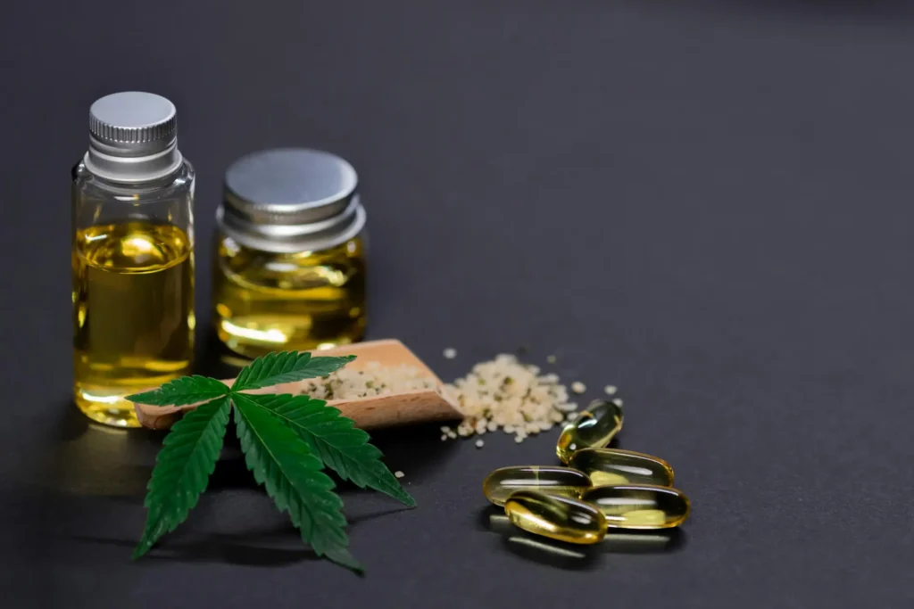Cannabis oil in glass jar with tablets and grains on the side.